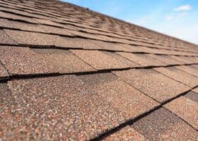 Close up photo of asphalt shingles layer on top of roof on new house under construction